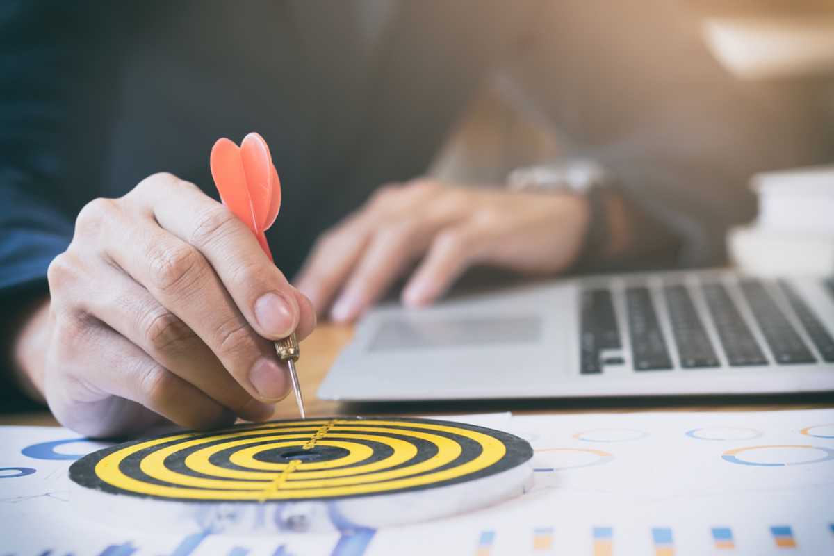 Pessoa segurando um dardo em direção a um alvo